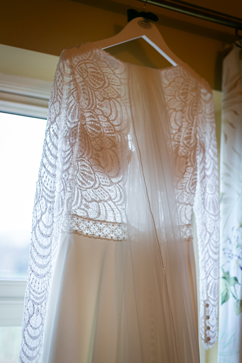 Close up shot of the brides wedding dress hung by a window at the Heights Hotel in Killarney.