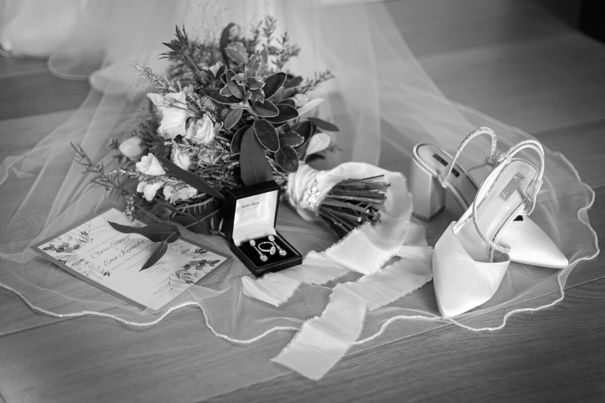 Beautifully styled black and white shot of the brides wedding bouquet, jewellery and shoes at the Heights Hotel, Killarney.