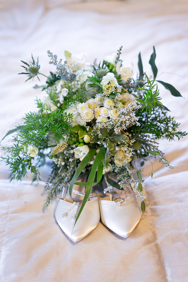 Beautifully styled shot of the brides wedding ring, bouquet and shoes at the Heights Hotel, Killarney.