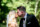 bride and groom kissing in the sunshine with blurred greenery in background