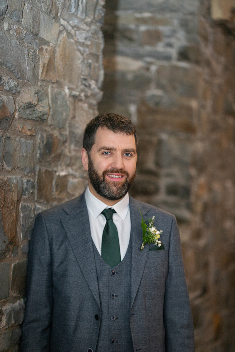 Portrait of the groom smiling at the camera in Killarney town.