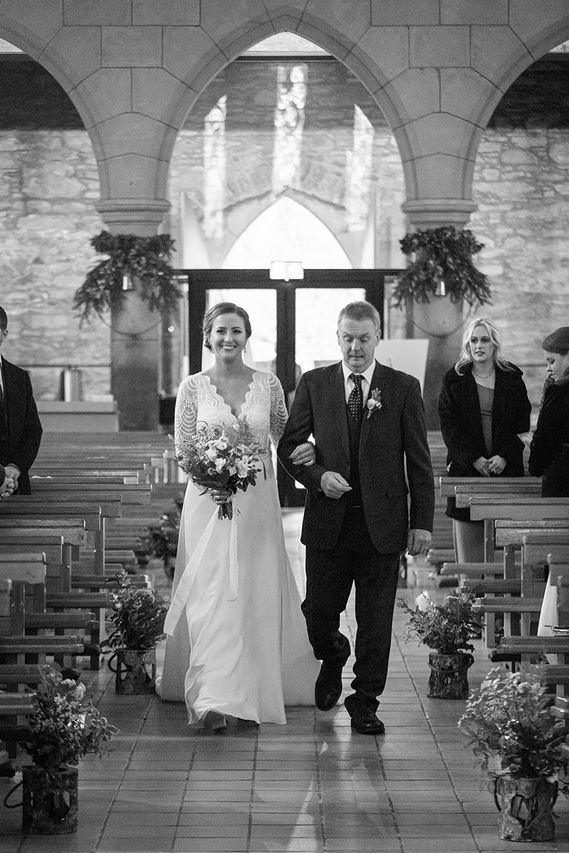Black and white portrait of the bride walking down the aisle with her father at St Marys cathedral, Killarney.
