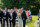 bride joins groom at the alter holding wedding bouquet surrounded by family and guests in the scenic grounds of the dunloe hotel