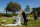bride and groom share a kiss in the sunshine with the scenery of the dunloe hotel gardens in the background