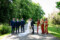The bride and groom stand centred between their groomsmen and bridemaids sharing a kiss, surrounded by the picturesque trees, shrubs and flowers of Ballyseede castle hotel.