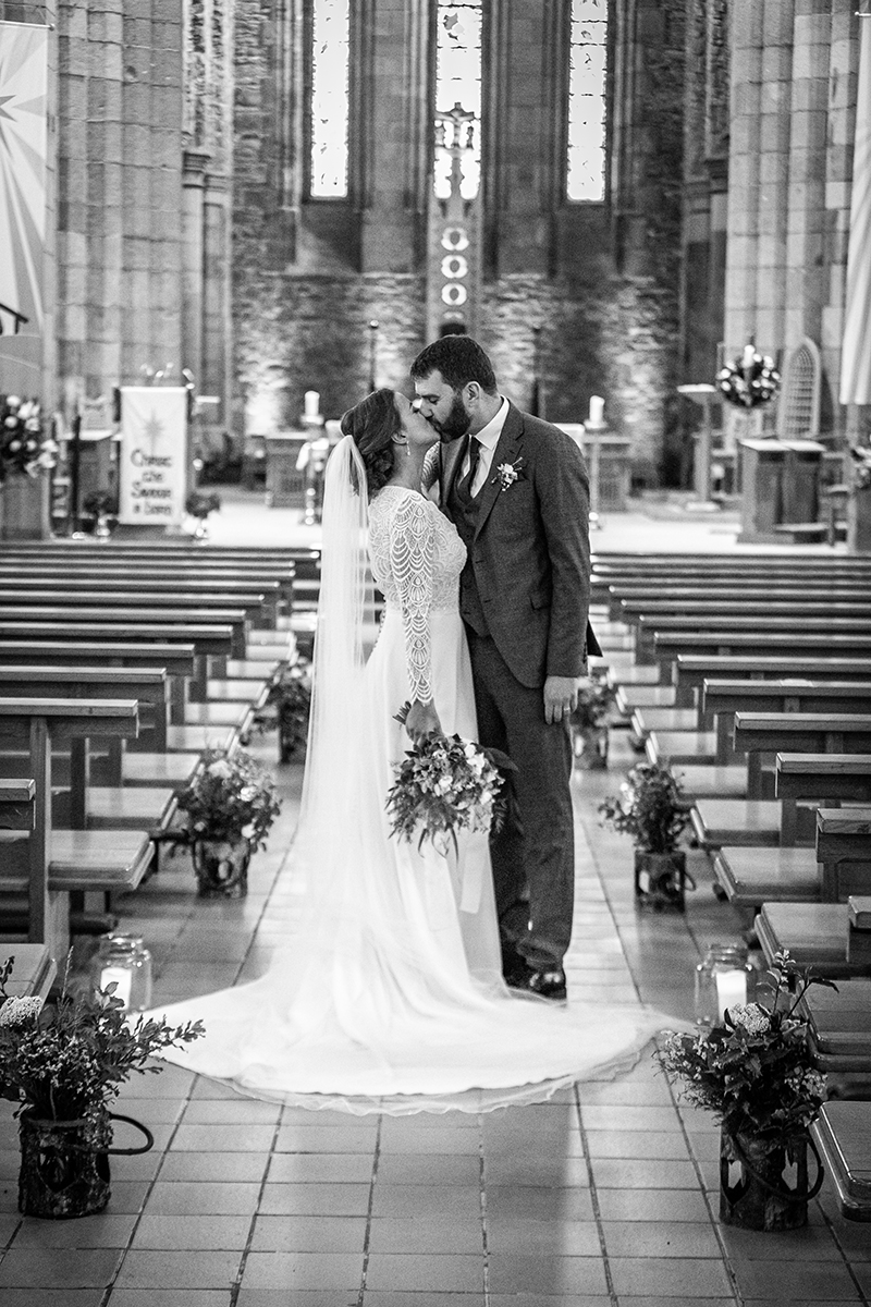 Black and white portrait of bride and groom sharing a kiss inside St Marys cathedral, Killarney.