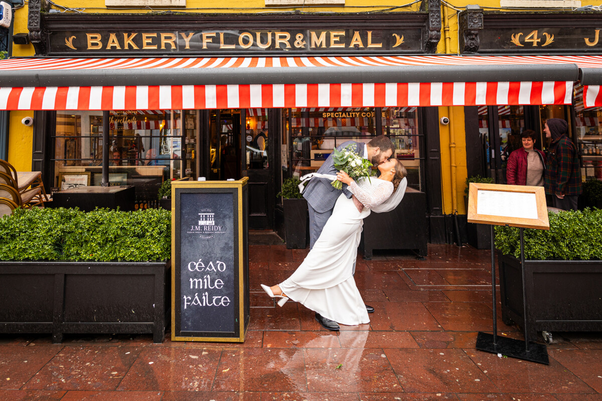 Bride and Groom share a kiss outside of JM Reidys in Killarney.