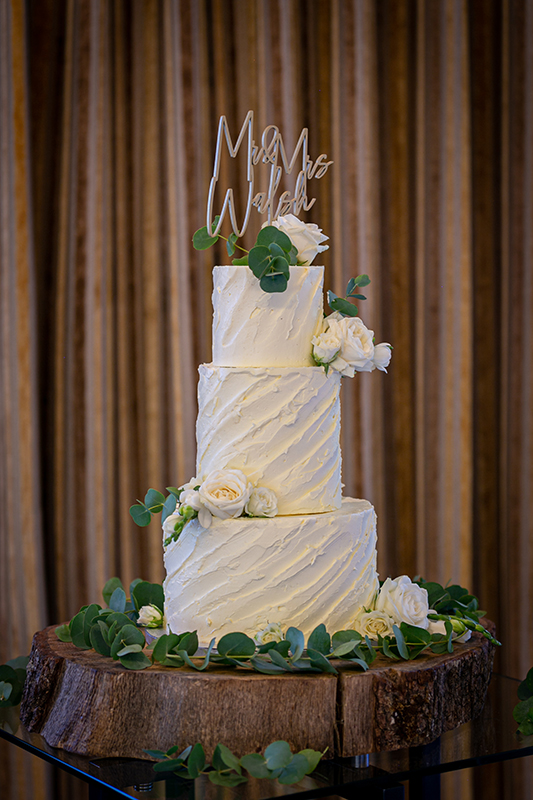 white wedding cake surrounded by white and green florals at the dunloe hotel