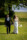Bride and groom walk hand in hand with big smiles on their faces through the grounds of Dromquinna Manor.