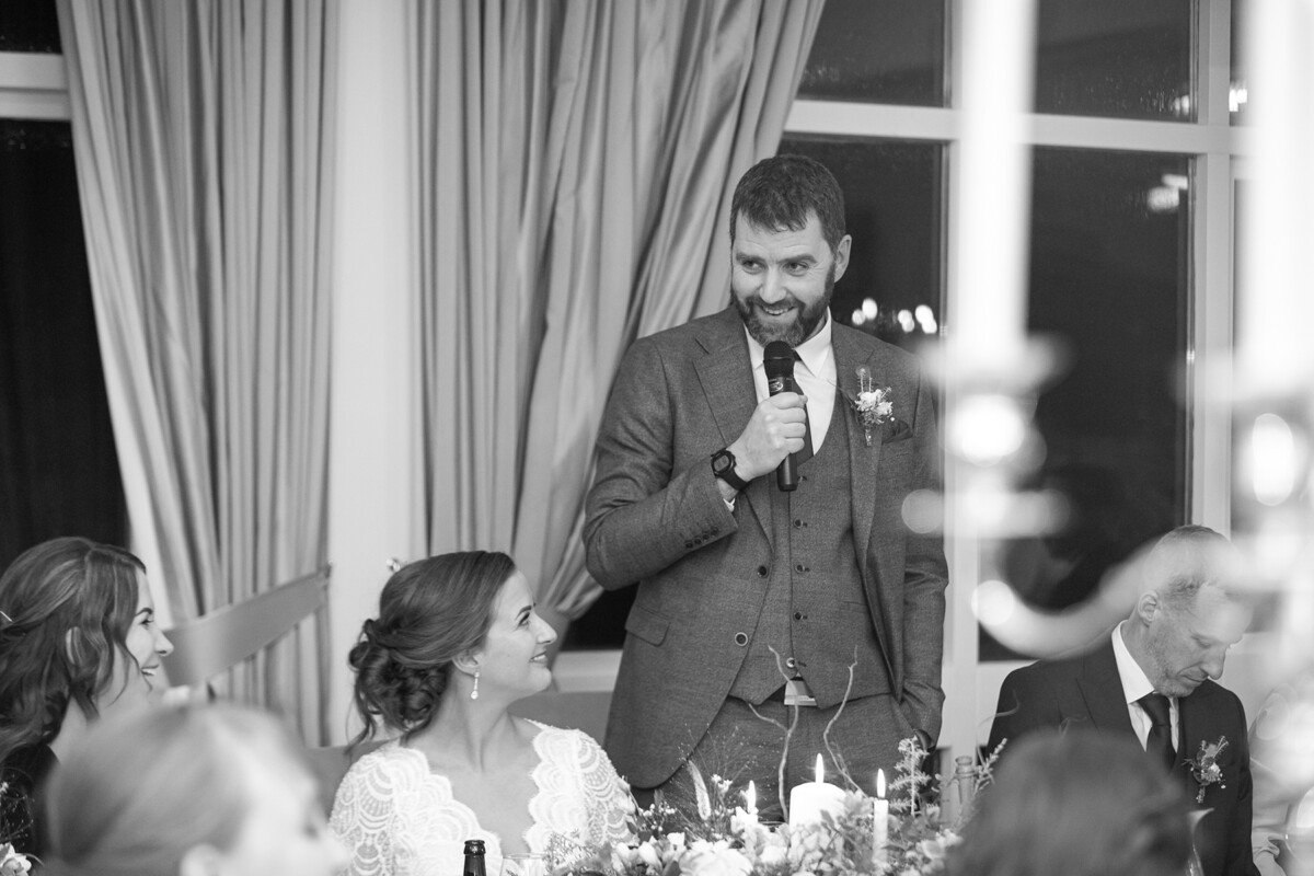 Black and white photograph of groom giving wedding speech at his wedding reception in Killarney.