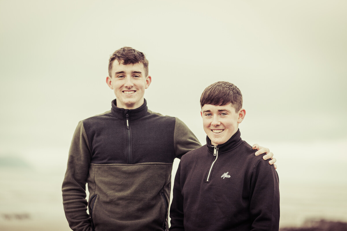 beach portrait of two brothers smiling set on ballyheigue beach county kerry