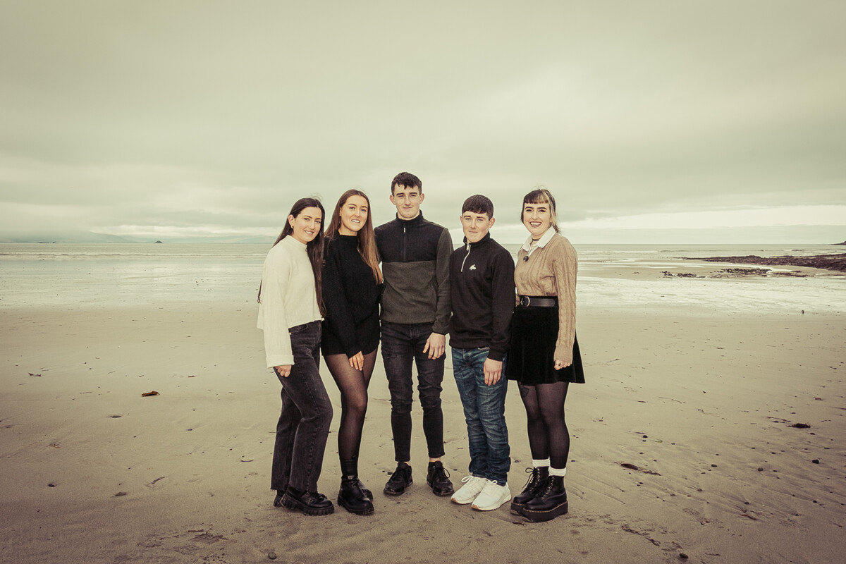 beach portrait of brothers and sisters stood smiling on ballyheigue beach county kerry on a cloudy day