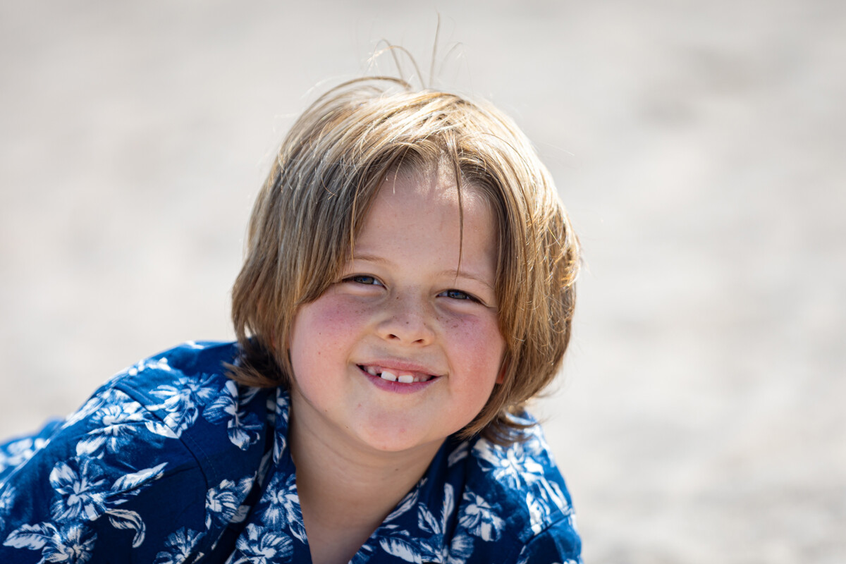 Close up beach portrait of a young boy with soft blurred background.