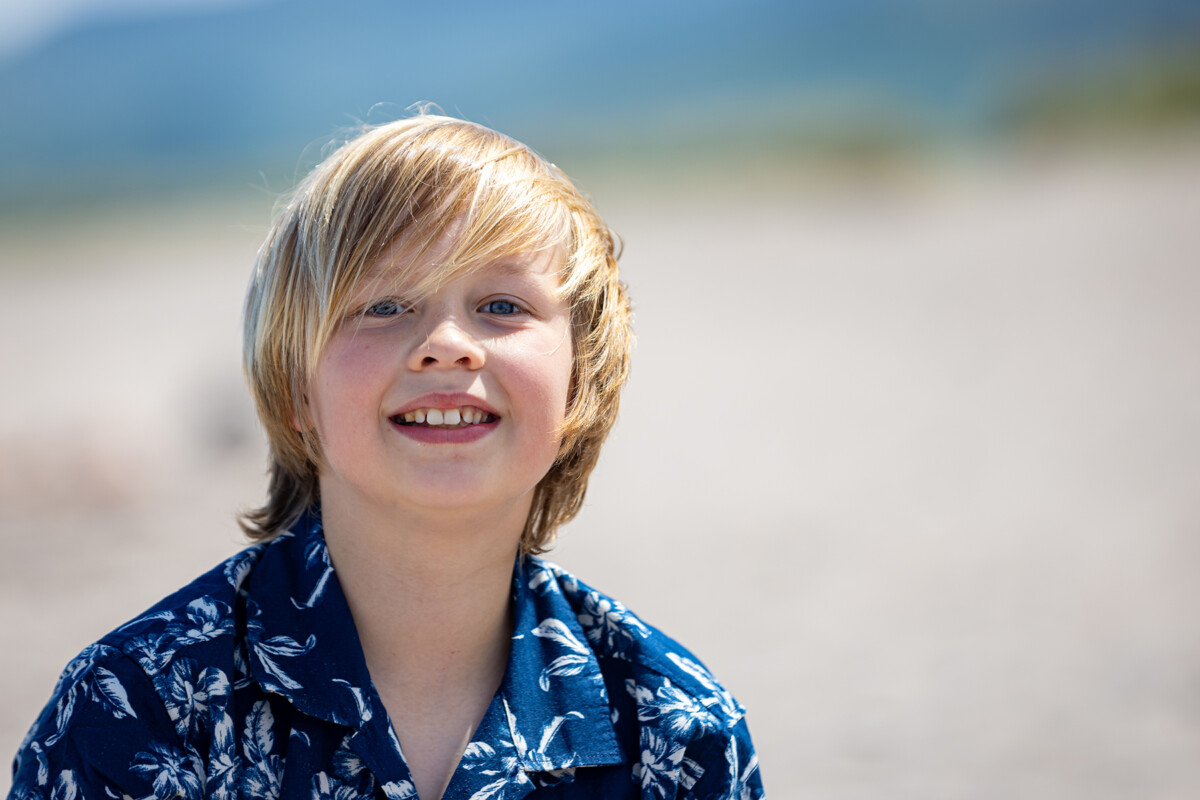 Close up beach portrait of a young boy with soft blurred background.
