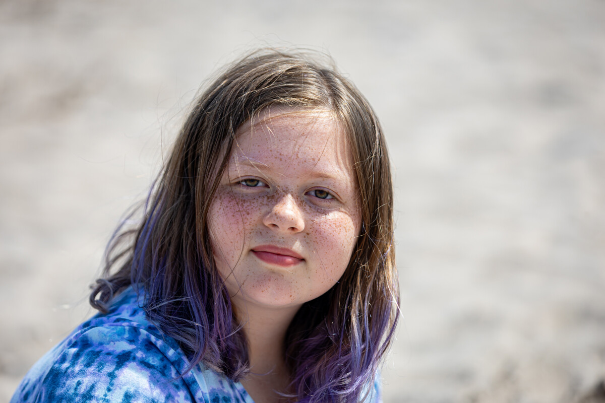 Close up beach portrait of a young girl with soft blurred background.