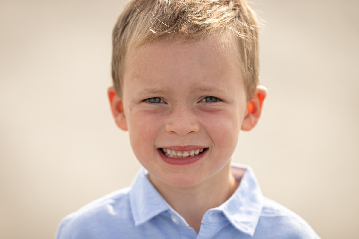 close up beach portrait of a little boy smiling at the camera