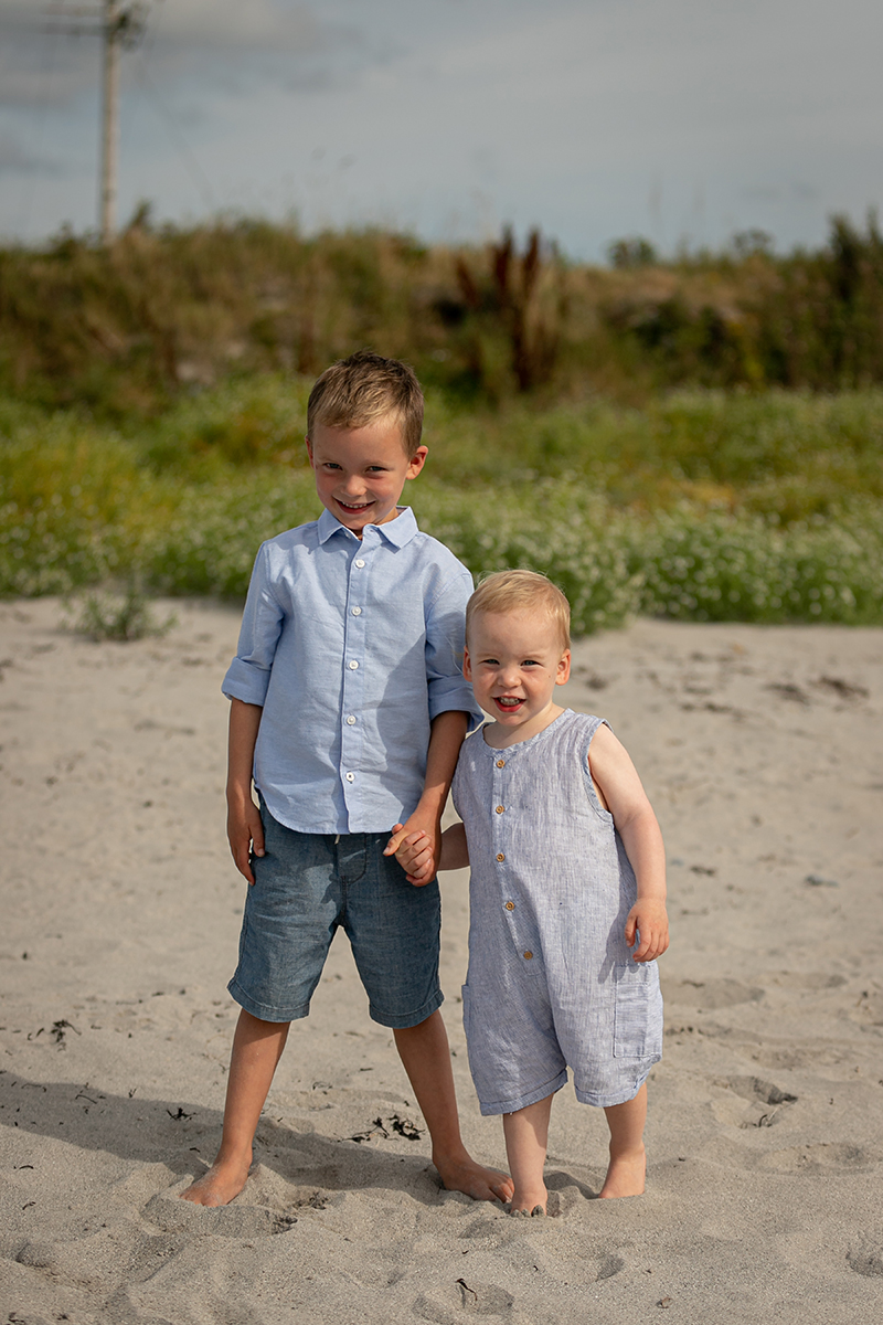 beach portrait of two young brothers stood in the sand at fenit beach