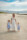 beach portrait of mother holding hand with her children facing the camera at fenit beach with mountains and blue sky in background