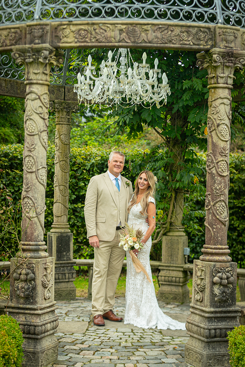 Husband and wife pictured standing in the centre of the stone gazebo in the Ballyseede castle gardens surrounded by greenery.