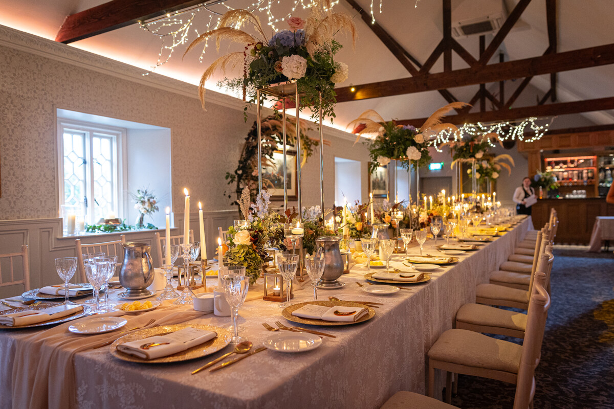 Dining hall decorated with florals and gold accents for wedding vow renewal at Ballyseede castle hotel, Tralee.